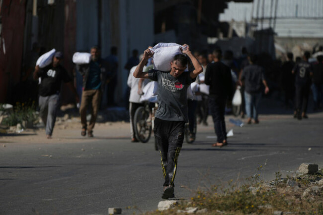 palestinians-carry-bags-of-flour-after-storming-a-u-n-world-food-program-warehouse-in-zawaida-central-gaza-strip-on-wednesday-may-28-2025-ap-photoabdel-kareem-hana