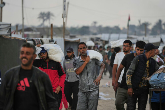 palestinians-carry-bags-filled-with-food-and-humanitarian-aid-provided-by-the-gaza-humanitarian-foundation-a-u-s-backed-organization-approved-by-israel-in-khan-younis-southern-gaza-strip-on-tuesd