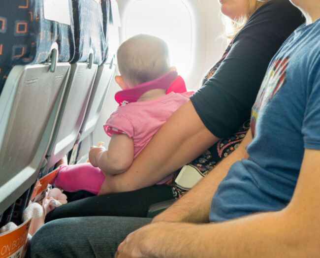 a-baby-on-its-parents-lap-on-a-passenger-plane