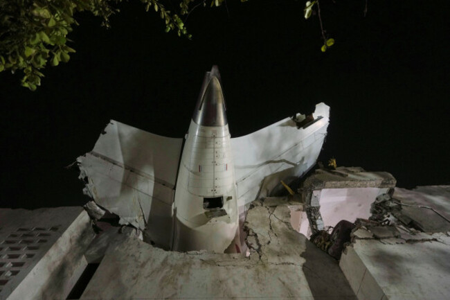 the-tail-of-the-airplane-is-seen-stuck-in-a-building-at-the-site-of-an-airplane-that-crashed-in-indias-northwestern-city-of-ahmedabad-in-gujarat-state-thursday-june-12-2025-ap-photoajit-solanki