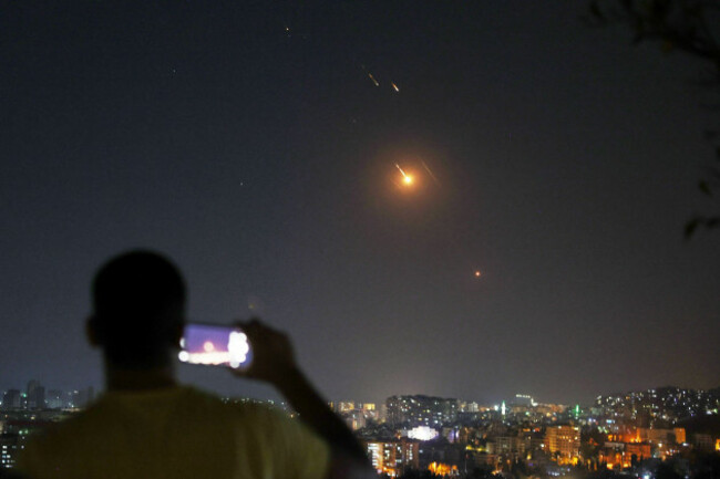 a-man-takes-a-cellphone-photo-as-missiles-fired-from-iran-toward-israel-fly-over-syrian-territory-in-damascus-syria-early-wednesday-june-18-2025-ap-photoghaith-alsayed