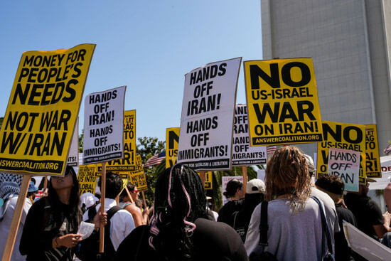 two-anti-war-demonstrators-hold-signs-outside-the-wilshire-federal-building-in-los-angeles-sunday-june-22-2025-following-u-s-airstrikes-on-irans-nuclear-facilities-ap-photojae-c-hong