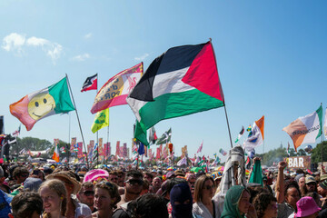 the-flag-of-palestine-is-waved-in-a-crowd-of-festivalgoers-at-the-hip-hop-trio-kneecaps-performance-during-the-glastonbury-festival-in-worthy-farm-somerset-england-saturday-june-28-2025-scott