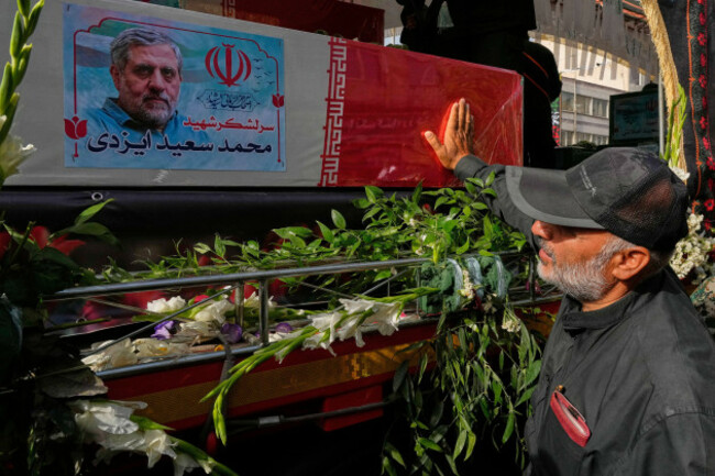 a-mourner-touches-the-flag-draped-coffin-of-mohammad-saeed-izadi-a-top-commander-of-irans-paramilitary-revolutionary-guard-during-the-funeral-ceremony-of-the-iranian-armed-forces-generals-nuclear