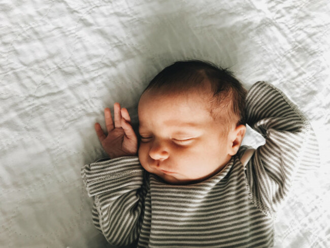 a-newborn-baby-girl-asleep-in-a-striped-shirt