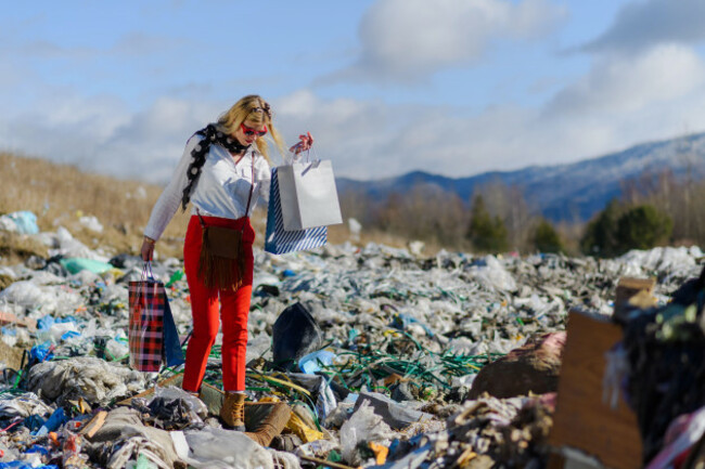 modern-woman-on-landfill-with-shopping-bags-consumerism-versus-pollution-concept