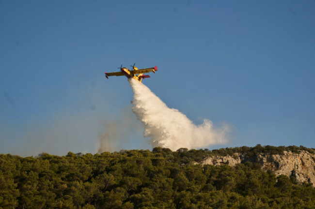 a-firefighting-airplane-drops-water-as-a-wildfire-burns-in-rafina-east-of-athens-greece-thursday-july-3-2025-with-several-houses-destroyed-from-the-fire-in-the-area-ap-photopetros-giannakouri