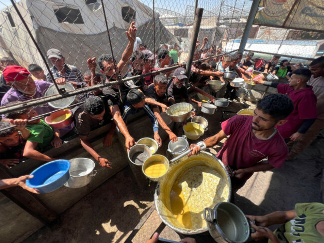 khan-younis-gaza-06th-july-2025-palestinians-crowd-to-receive-a-hot-meal-at-a-food-distribution-point-in-khan-younis-southern-gaza-on-sunday-july-6-2025-human-rights-groups-say-that-gazas-po