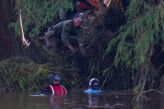 officials-are-seen-in-the-guadalupe-river-as-they-assist-in-recovery-efforts-after-a-flash-flood-swept-through-the-area-sunday-july-6-2025-in-hunt-texas-ap-photojulio-cortez