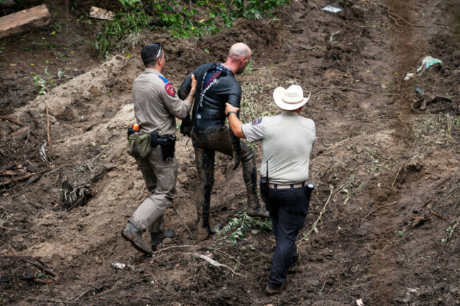 a-texas-department-of-public-safety-trooper-and-kerr-county-sheriffs-deputy-assist-a-rescue-diver-out-of-the-water-at-a-search-and-rescue-site-along-the-guadalupe-river-after-a-flash-flood-swept-thro