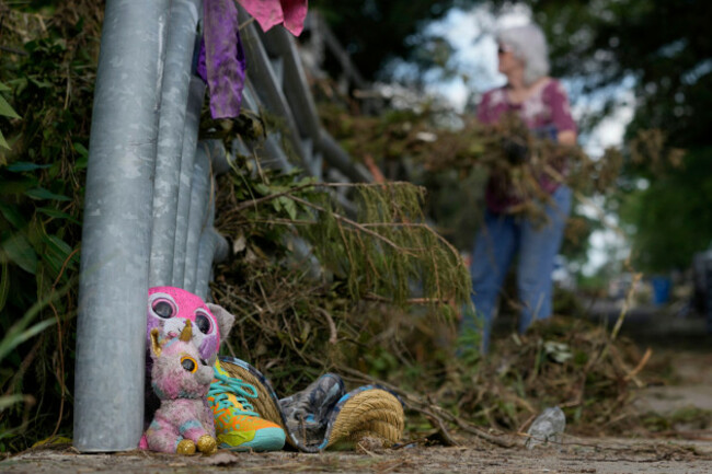 lost-items-sit-at-a-bridge-as-a-volunteer-cleans-up-debris-on-tuesday-july-8-2025-after-a-flash-flood-swept-through-the-area-in-kerrville-texas-ap-photoashley-landis