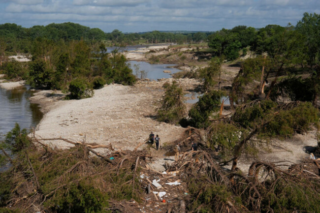 search-and-rescue-teams-from-kerrville-fire-department-walk-past-debris-after-flooding-near-the-banks-of-the-guadalupe-river-in-kerrville-texas-on-tuesday-july-8-2025-ap-photoashley-landis