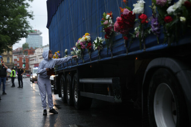 sarajevo-bosnia-and-herzegovina-09th-july-2025-a-child-places-a-flower-on-a-truck-carrying-remains-of-the-identified-victims-of-the-1995-srebrenica-massacre-to-the-memorial-centre-in-potocari-whe