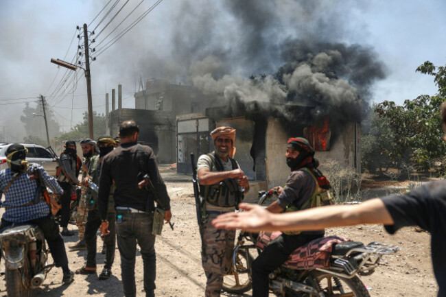 bedouin-fighters-gather-in-front-a-burned-shop-at-mazraa-village-on-the-outskirts-of-sweida-city-during-clashes-between-the-bedouin-clans-and-druze-militias-southern-syria-friday-july-18-2025-a