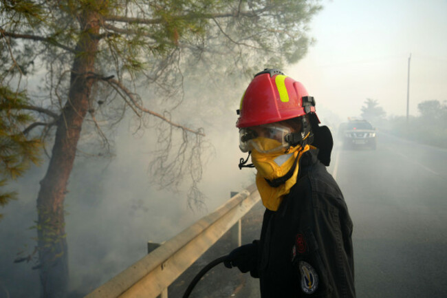 a-firefighter-along-with-her-colleagues-try-to-extinguish-a-fire-in-souni-village-cyprus-during-a-massive-wildfire-on-the-southern-side-of-the-east-mediterranean-island-nations-troodos-mountain-ran