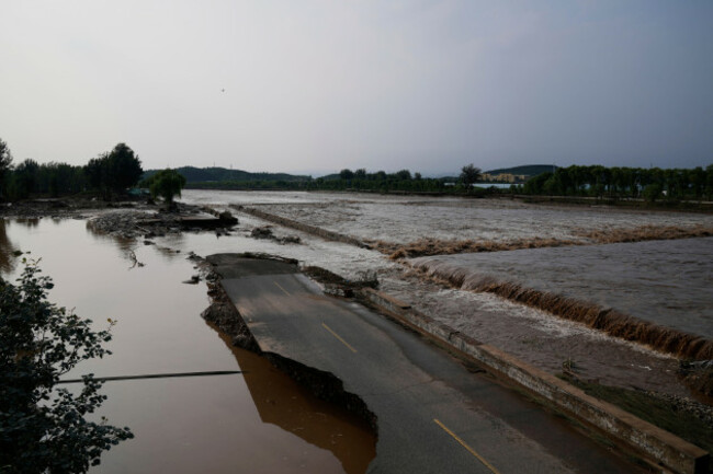 a-damage-road-is-seen-at-a-flooded-area-after-heavy-rains-in-miyun-district-on-the-outskirts-of-beijing-china-monday-july-28-2025-ap-photomahesh-kumar-a