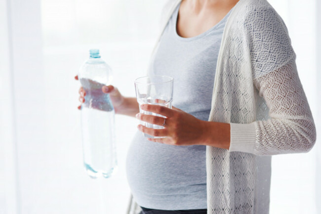 unrecognizable-pregnant-woman-drinking-water