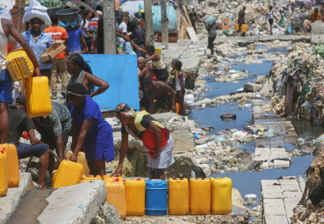people-wait-to-fill-their-containers-with-drinking-water-from-broken-underground-pipes-in-port-au-prince-haiti-friday-may-9-2025-ap-photoodelyn-joseph