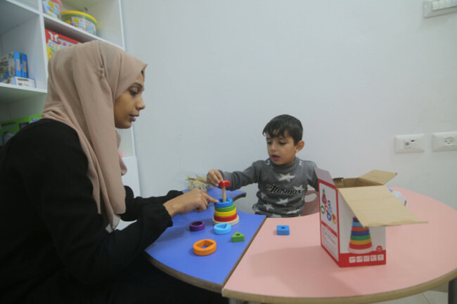 211123-rafah-nov-23-2021-a-palestinian-therapist-interacts-with-a-child-at-a-local-center-for-speech-therapy-and-language-rehabilitation-in-the-southern-gaza-strip-city-of-rafah-nov-23-202
