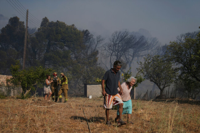 civil-protection-members-help-away-stamatina-86-right-and-her-daughter-eleftheria-left-in-the-background-during-a-fire-in-keratea-on-the-outskirts-of-athens-friday-aug-8-2025-ap-photothan
