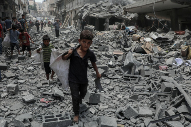 250819-gaza-aug-19-2025-xinhua-children-carrying-collected-items-walk-on-rubbles-after-an-israeli-airstrike-in-gaza-city-on-aug-8-2025-as-the-world-humanitarian-day-is-marked-across-c
