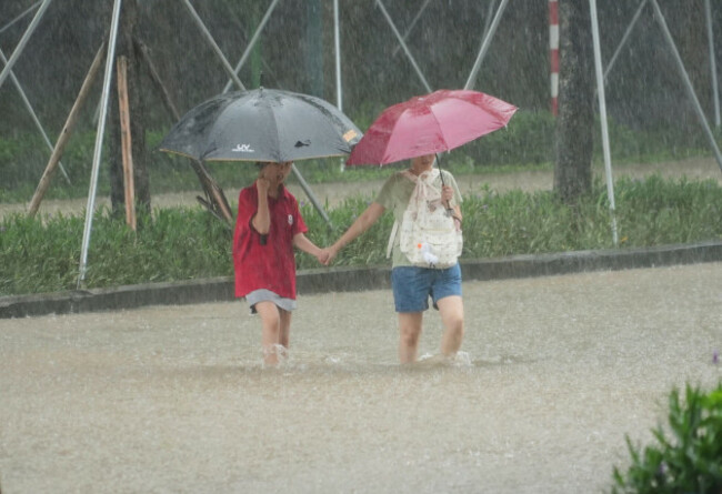 people-cross-a-flooded-street-in-the-rain-caused-by-typhoon-kajiki-in-hanoi-vietnam-tuesday-aug-26-2025-ap-photohau-dinh