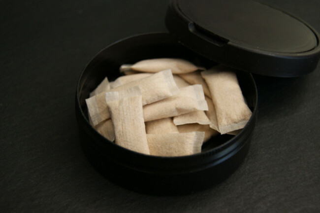 an-open-box-of-nicotine-pouches-nicotine-pads-in-black-packaging-on-a-dark-surface