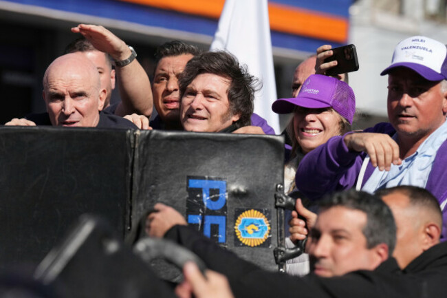 police-shield-argentine-president-javier-milei-and-his-sister-secretary-general-of-the-presidency-karina-milei-from-objects-thrown-at-them-by-protesters-amid-a-campaign-rally-ahead-of-legislative-p