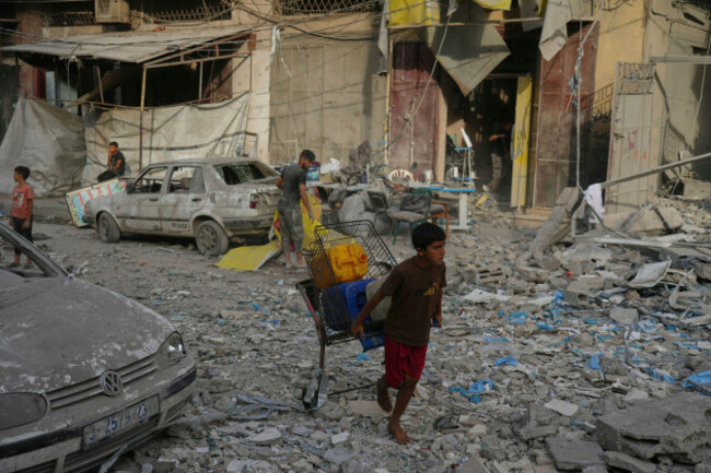 carrying-plastic-jerrycans-a-palestinian-boy-walks-past-a-heavily-damaged-building-in-the-rimal-neighborhood-in-gaza-city-sunday-aug-31-2025-a-day-after-it-was-hit-by-an-israeli-military-strike