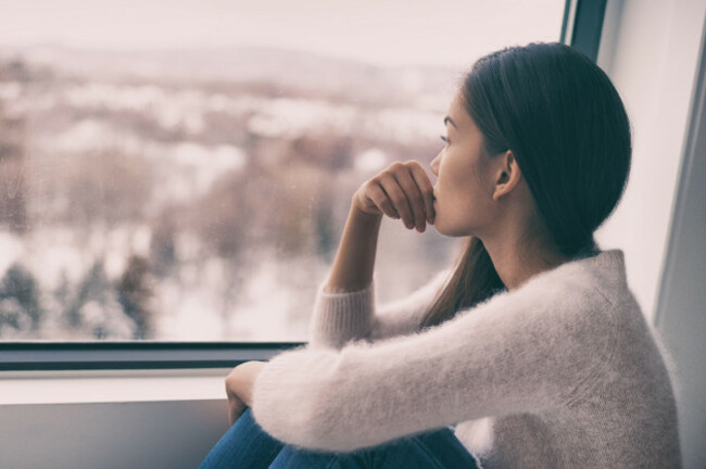winter-depression-seasonal-affective-disorder-mental-health-woman-sad-comtemplative-looking-out-the-window-alone