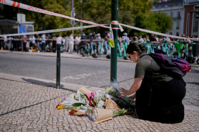 a-woman-places-flowers-at-the-site-where-a-tourist-streetcar-derailed-and-crashed-in-lisbon-portugal-thursday-sept-4-2025-ap-photoarmando-franca