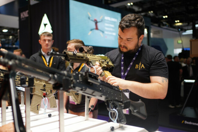 people-looking-at-some-of-the-weapons-on-display-at-the-defence-and-security-equipment-international-dsei-uk-the-flagship-defence-event-for-the-uk-at-excel-london-in-royal-victoria-dock-east-lond