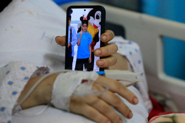 amani-bazzi-who-was-injured-sunday-in-the-town-of-bint-jbeil-shows-a-portrait-of-one-her-three-children-who-were-killed-after-an-israeli-drone-strike-hit-her-family-car-as-she-lies-in-tibnin-hospit