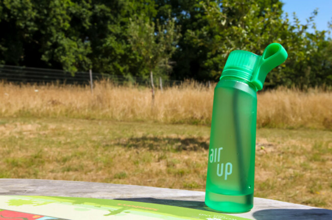 green-air-up-water-bottle-on-picnic-table-outside-surrey-england-uk-july-2022
