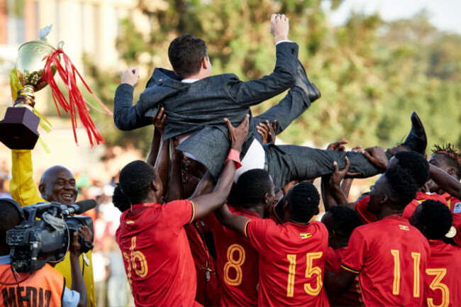 kampala-uganda-19-dec-2019-fred-kajoba-goalkeeping-coach-uganda-raises-the-trophy-as-uganda-players-lift-johnathan-mckinstry-head-coach-uganda-in-celebration-uganda-v-eritrea-final-cecaf