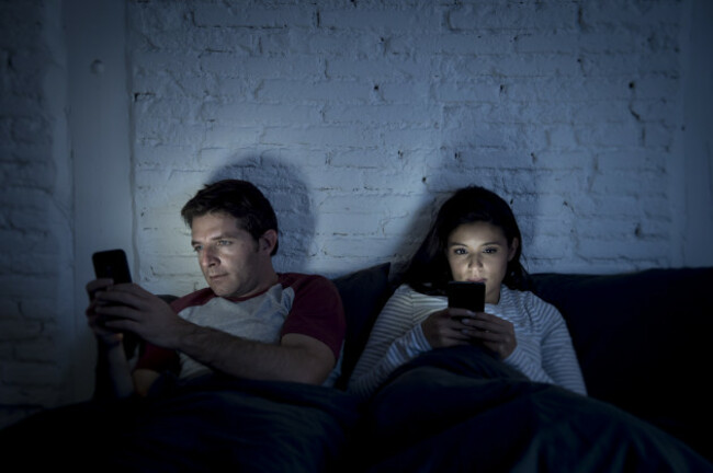 youngcoupleathomeinbedlateatnightusing