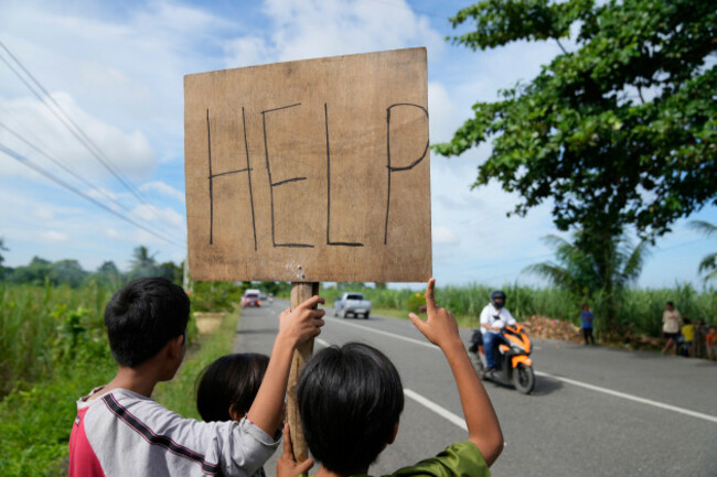 earthquake-survivors-hold-a-help-sign-along-a-road-thursday-oct-2-2025-days-after-a-strong-quake-struck-in-medellin-cebu-province-central-philippines-ap-photoaaron-favila
