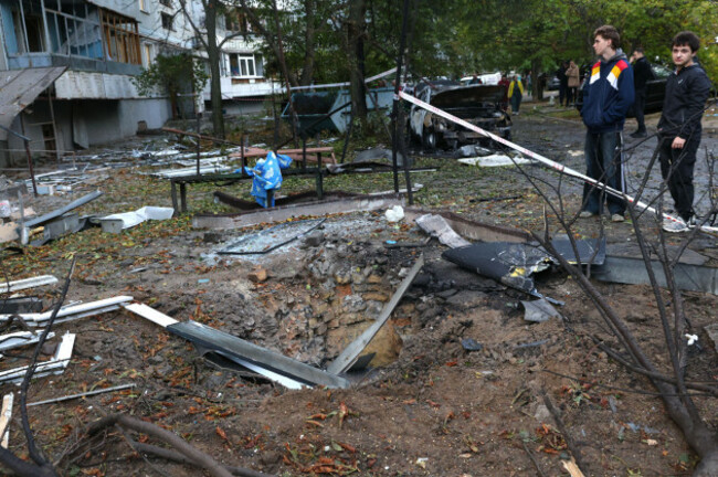 residents-stand-near-the-crater-in-front-of-a-house-destroyed-by-a-russian-strike-in-zaporizhzhia-ukraine-sunday-oct-5-2025-ap-photokateryna-klochko