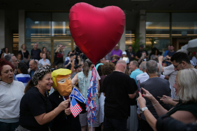 a-person-wears-a-mask-depicting-u-s-president-donald-trump-as-relatives-and-supporters-of-israeli-hostages-held-by-hamas-in-the-gaza-strip-celebrate-following-the-announcement-that-israel-and-hamas-h