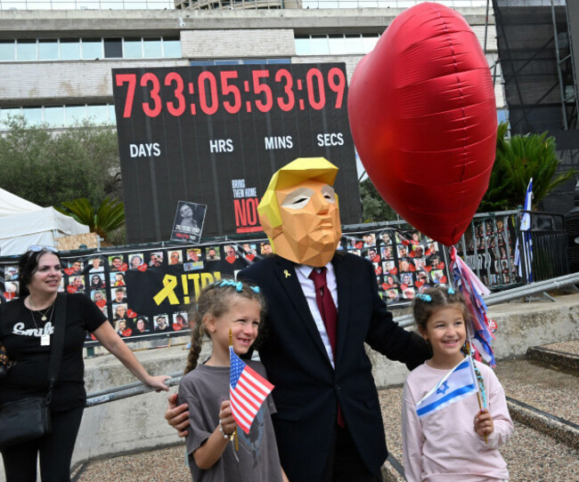 tel-aviv-israel-09th-oct-2025-a-person-wears-a-donald-trump-mask-for-a-photo-with-children-as-people-gather-in-hostage-square-in-tel-aviv-to-celebrate-the-agreement-for-u-s-president-donald-trump