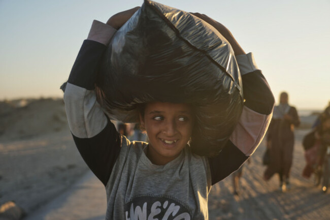 a-displaced-palestinian-girl-carries-a-bag-on-her-head-as-she-walks-along-the-coastal-road-near-wadi-gaza-in-the-central-gaza-strip-heading-toward-gaza-city-friday-oct-10-2025-after-israel-and-h