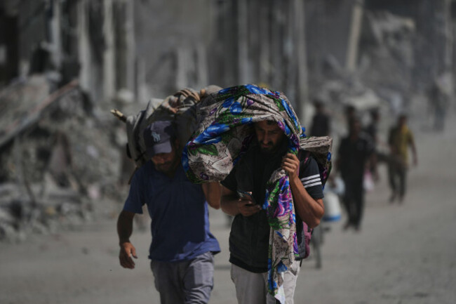 displaced-palestinians-carry-their-belongings-as-they-walk-along-the-heavily-damaged-al-jalaa-street-in-gaza-city-saturday-oct-11-2025-after-israel-and-hamas-agreed-to-a-pause-in-their-war-and-th