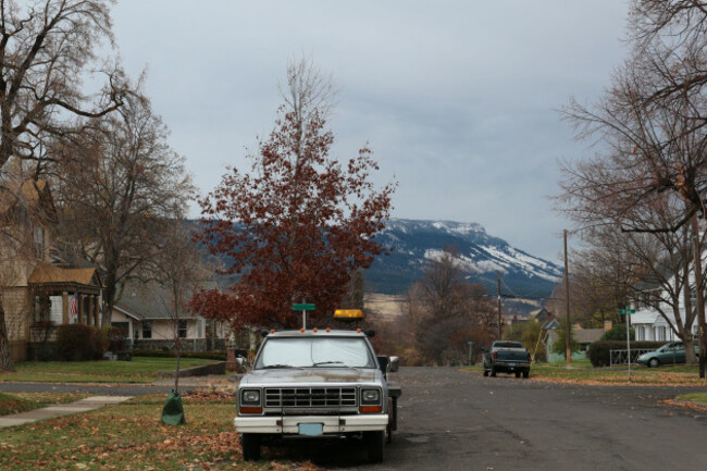 a-chilly-crisp-fall-day-in-a-small-town-in-us-looking-down-a-street-with-an-old-truck-fall-colored-trees-and-the-mountain-with-snow-creeping-down