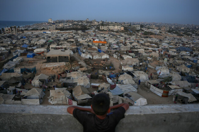 a-boy-looks-at-a-makeshift-tent-camp-for-displaced-palestinians-stretching-across-an-area-in-zawaida-in-the-central-gaza-strip-saturday-nov-1-2025ap-photoabdel-kareem-hana