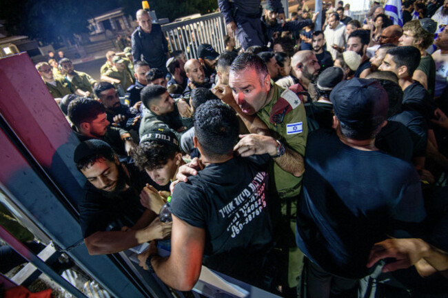 israel-29th-july-2024-an-idf-officer-speaks-with-right-wing-activists-as-they-try-to-brake-into-the-beit-lid-base-israeli-right-wing-activists-demonstrated-with-masked-idf-reservists-from-the-100