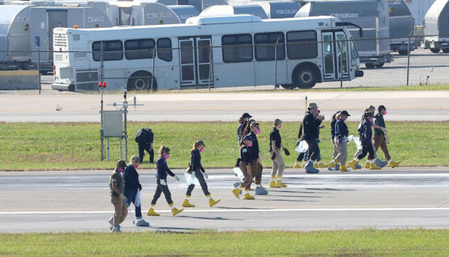 louisville-united-states-05th-nov-2025-members-of-the-national-transportation-safety-board-ntsb-and-fbi-agents-walk-the-runway-looking-for-evidence-from-the-ups-flight-2976-md-11-that-crashed-tu