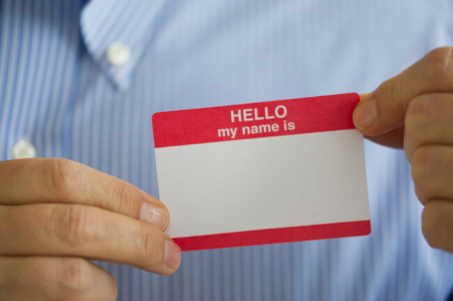 jersey-city-new-jersey-close-up-of-businessmans-hands-holding-blank-name-tag-studio-shot