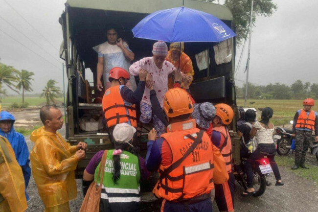 in-this-photo-provided-by-the-philippine-coast-guard-rescuers-evacuate-residents-in-sablayan-occidental-mindoro-province-of-the-philippines-as-typhoon-fung-wong-batters-the-country-on-sunday-nov-9