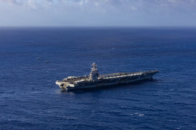 two-fa-18e-super-hornets-attached-to-strike-fighter-squadron-87-fly-over-the-worlds-largest-aircraft-carrier-uss-gerald-r-ford-cvn-78-during-an-in-flight-change-of-command-in-which-cmdr-brando