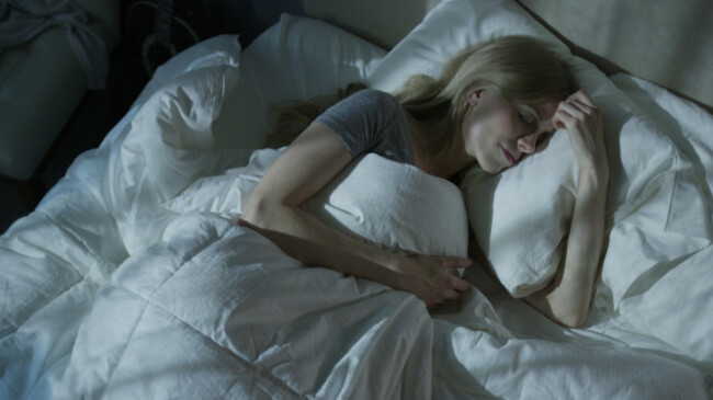 high-angle-view-of-relaxed-woman-dreaming-and-sleeping-under-duvet-in-bed